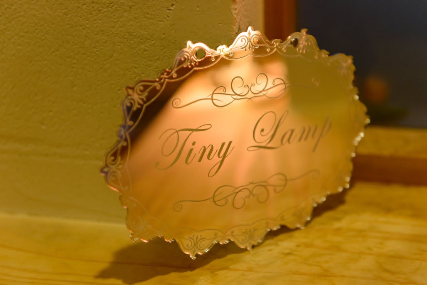 灯りに照らされた Tiny Lamp の真鍮の看板